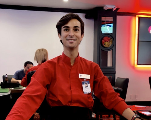 Dealer in a red shirt smiling