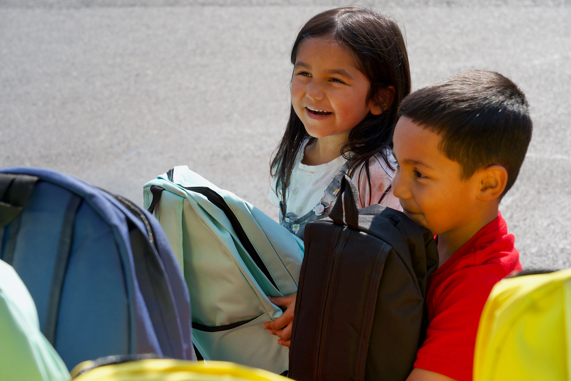 Two kids smiling with backpacks